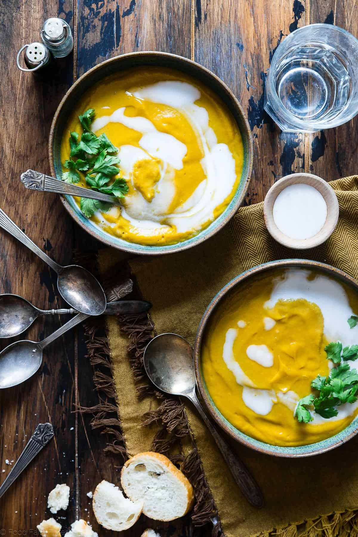 Coconut Curry Roasted Butternut Squash Soup - This spicy, paleo and vegan butternut squash soup is so creamy you'll never believe it's healthy, whole30 compliant and gluten and dairy free! | #Foodfaithfitness | #paleo #whole30 #vegan #dairyfree #soup two bowls of paleo butternut squash soup on a table with spoons around