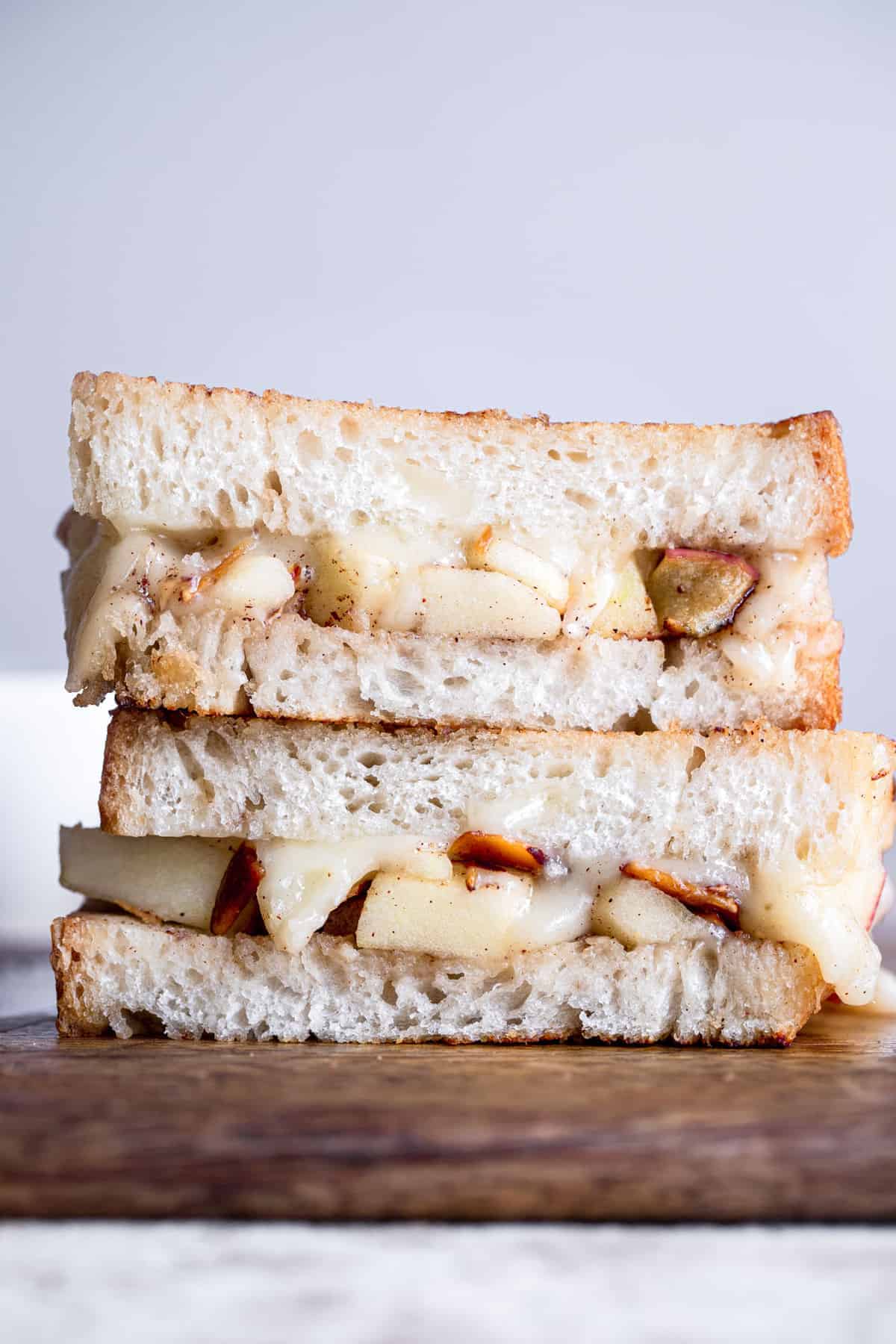 Brie Grilled Cheese with Apples - This grilled cheese is made extra delicious with creamy brie and sweet and crispy apples! An adult grilled cheese that feels SO fancy but is SO easy to make! | #Foodfaithfitness | #Glutenfree #Grilledcheese #Lunch #Sandwich a brie grilled cheese sandwich on a cutting board