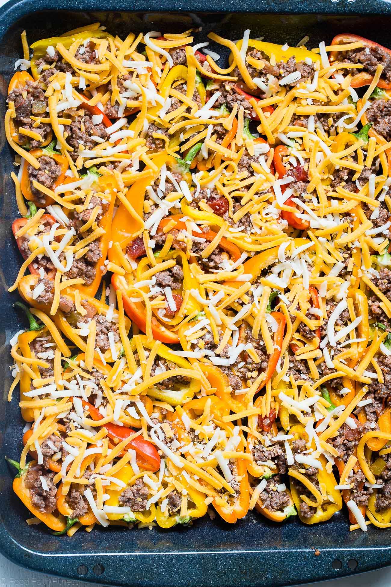 Putting cheese on mini bell pepper nachos. Recipe on Foodfaithfitness.com