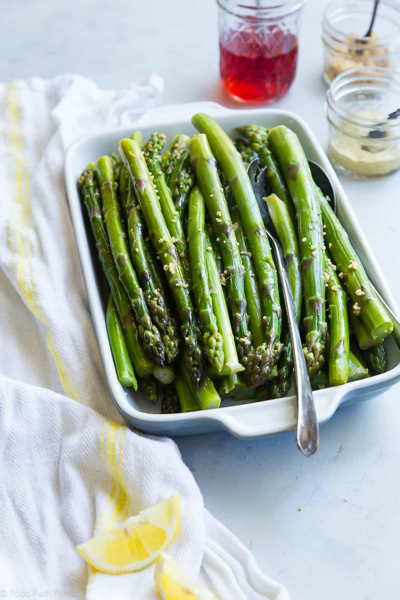 Blanched asparagus in a serving dish. Recipe on foodfaithfitness.com