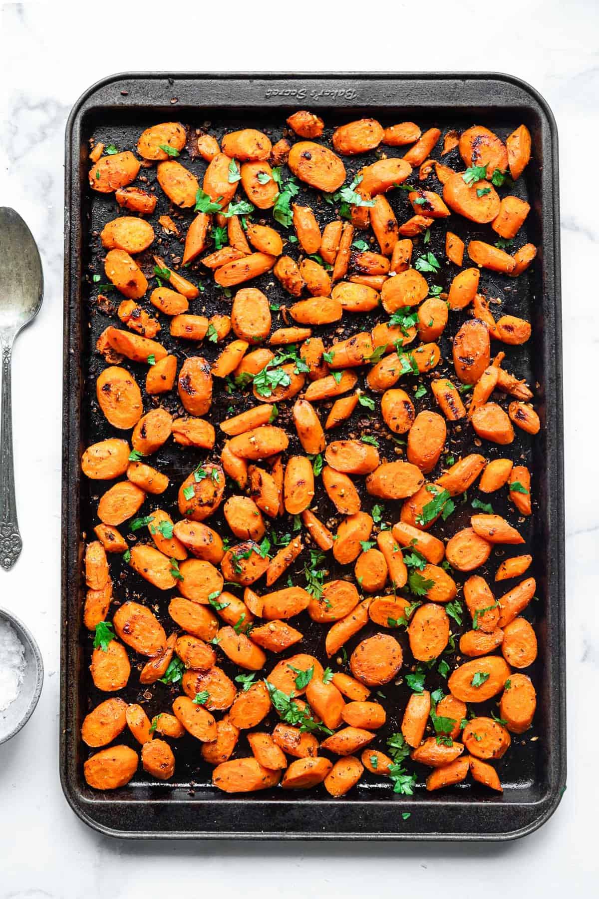 Cumin Roasted Carrots - These easy Roasted Carrots are roasted in coconut oil and delicious spices for an easy, healthy side dish that is naturally gluten free, vegan and paleo! | #Foodfaithfitness | #glutenfree #paleo #vegan #whole30 cumin roasted carrots on a sheet pan