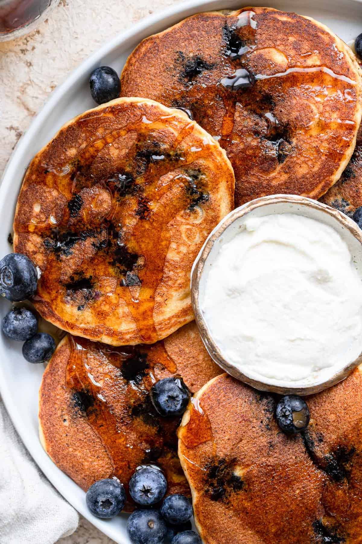 Whole Wheat Ricotta Blueberry Pancakes - These whole wheat blueberry pancakes are big, fluffy and creamy thanks to the addition of Ricotta Cheese! Easy, healthy and packed with protein! | #Foodfaithfitness | #glutenfree #healthy #wholewheat #pancakes Whole Wheat Blueberry Pancakes with ricotta cheese on plate