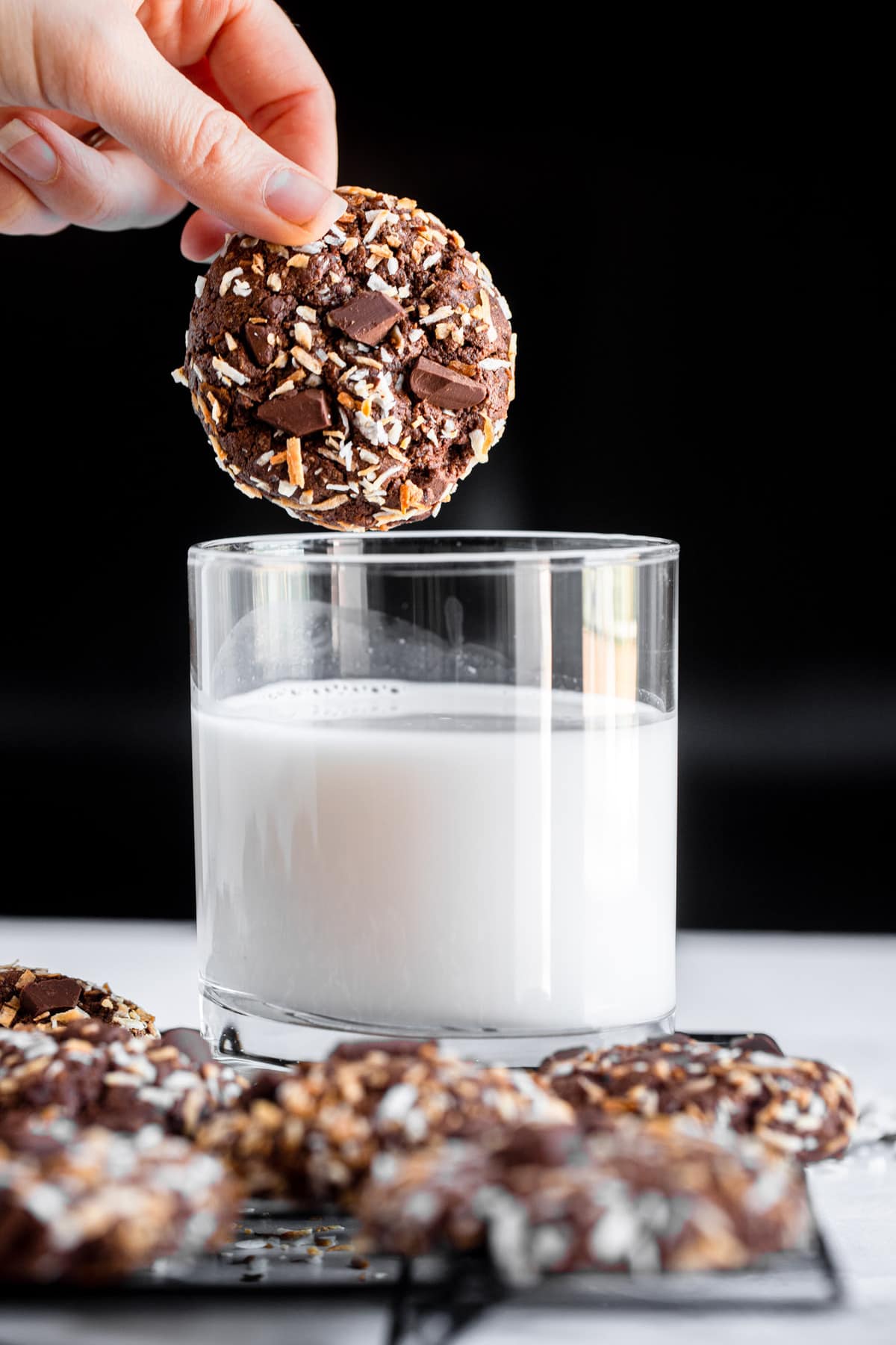 quinoa cookie being dipped into a glass on milk