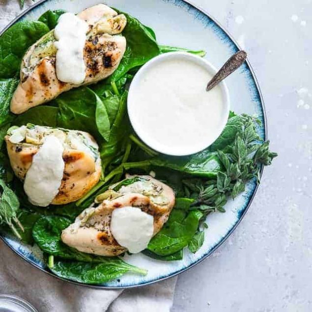 Spinach Artichoke Greek Yogurt Chicken - Chicken is stuffed, grilled and topped with a creamy, Parmesan Greek yogurt sauce! It's a healthy, low carb dinner that's perfect for a weeknight, and only 1 WW Freestyle point! | #Foodfaithfitness | #GreekYogurt #LowCarb #Healthy #Glutenfree #ChickenDinner