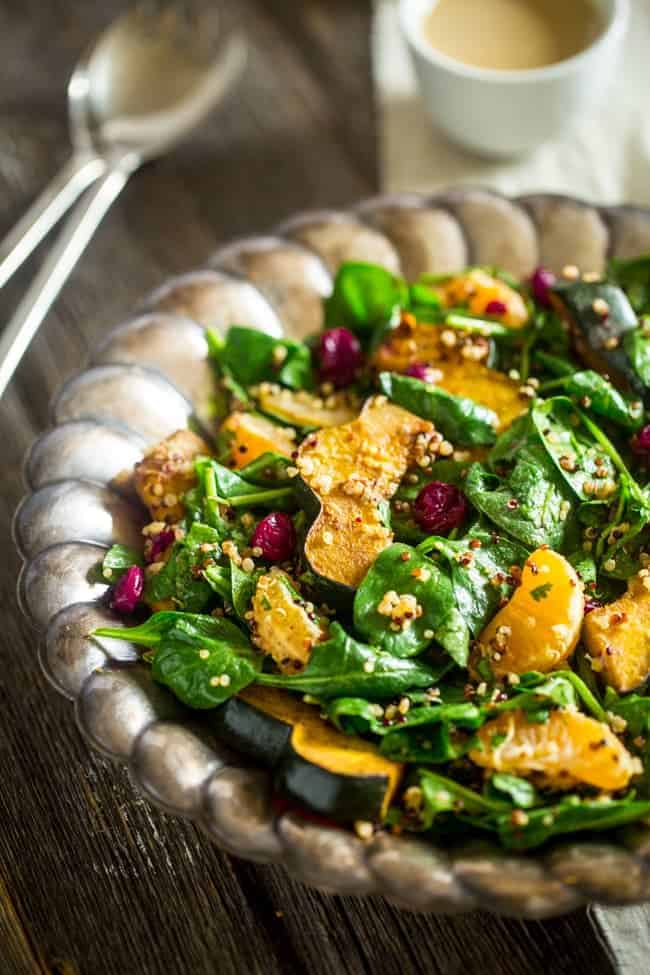 Vegan Maple Tahini Orange Roasted Acorn Squash and Cranberry Quinoa Salad - This healthy salad is mixed with maple roasted acorn squash, cranberries and oranges for a fall meal that is gluten free and vegan friendly. Perfect for Thanksgiving of Friendsgiving! | Foodfaithfitness.com | @FoodFaithFit