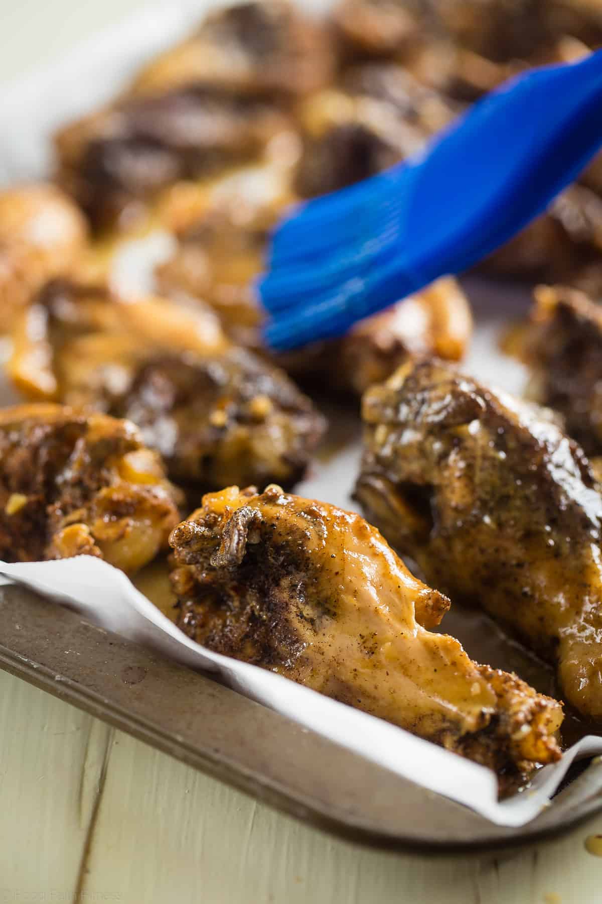 Sticky Asian Paleo Whole30 Chicken Wings - These sticky slow cooker Paleo Chicken wings are bursting with sweet and tangy Asian flavor! You'd never know they're a healthier, gluten free appetizer! | #Foodfaithfitness | #glutenfree #dairyfree #whole30 #paleo #healthy rubbing sauce onto whole30 chicken wings