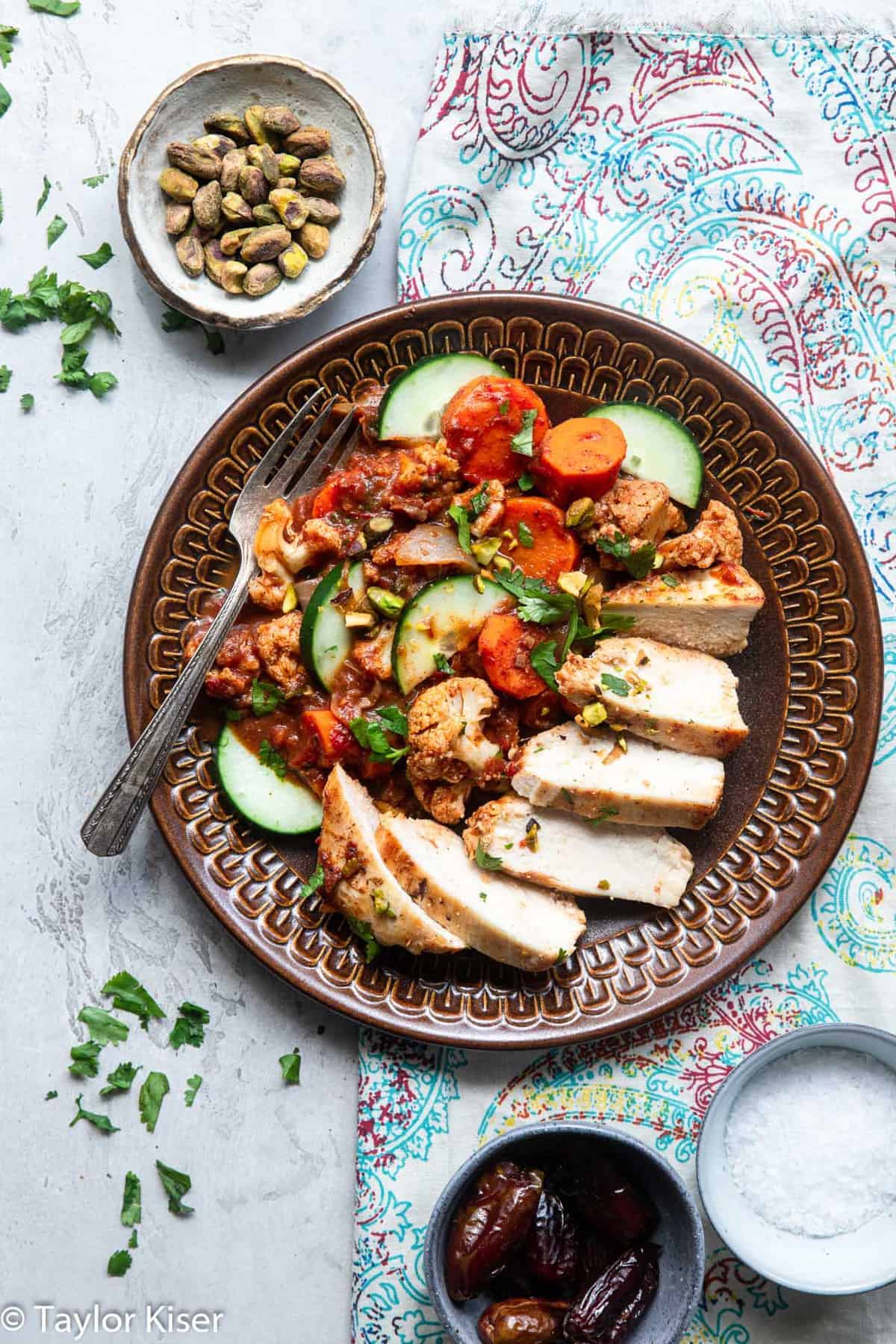 Whole30 Moroccan Chicken - This quick and easy one-pan, 30 minute Easy Moroccan Chicken Recipe is LOADED with spicy-sweet flavor. It's a gluten free, paleo friendly weeknight dinner! | #Foodfaithfitness | #Glutenfree #dairyfree #paleo #healthy #lowcarb Moroccan Chicken on a plate with pistachios