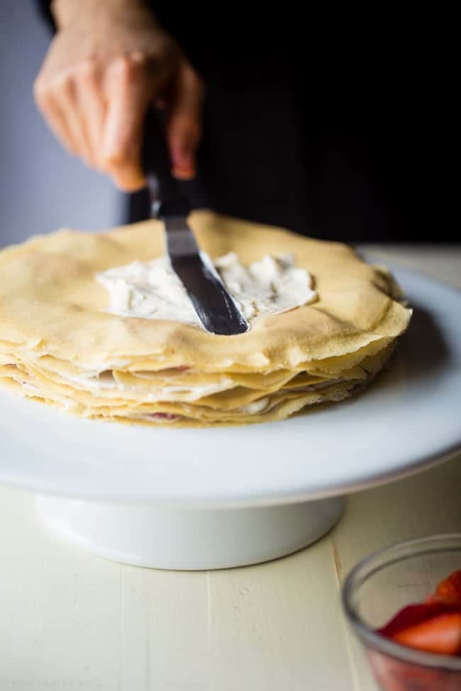 Strawberry Lemon Paleo Crepe Cake with Coconut Cream - This cake is made out of paleo crepes layered with rich, sweet lemon coconut cream and fresh strawberries. It's a gluten free dessert, that's perfect for a spring brunch or Mothers day! | Foodfaithfitness.com | @FoodFaithFit