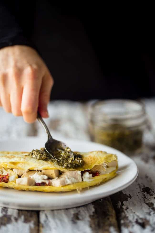 Pesto Chicken Egg White Omelette with Goat Cheese - This quick and easy, protein packed egg white omelette is mixed with chicken, creamy goat cheese and topped with pesto! It's a low carb and gluten free breakfast for busy mornings! | Foodfaithfitness.com | @FoodFaithFit