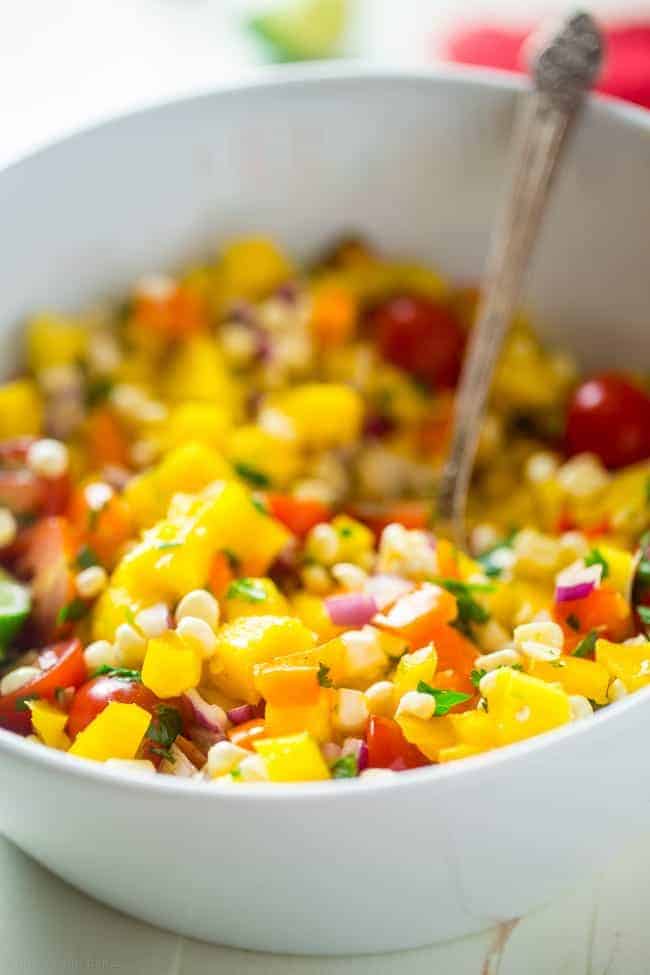 Vegan Fresh Corn and Mango Salad - This healthy salad has fresh corn, juicy, sweet mangos and tons of crispy, fresh vegetables! It's the perfect, quick and easy side dish for summer that is under 100 calories! | Foodfaithfitness.com | @FoodFaithFit