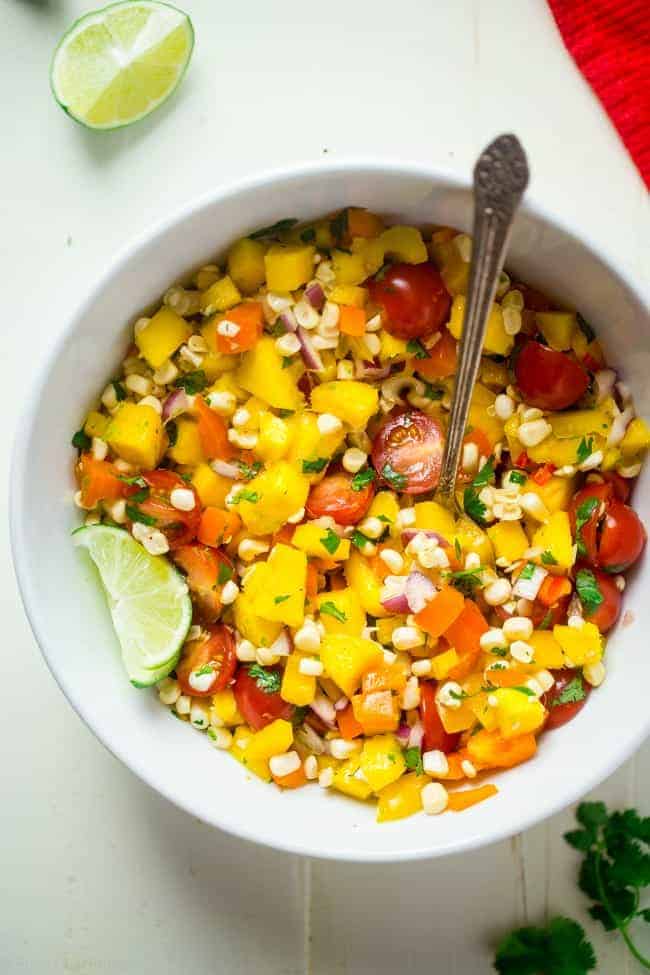 Vegan Fresh Corn and Mango Salad - This healthy salad has fresh corn, juicy, sweet mangos and tons of crispy, fresh vegetables! It's the perfect, quick and easy side dish for summer that is under 100 calories! | Foodfaithfitness.com | @FoodFaithFit
