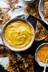 Healthy pumpkin pie dip in a rustic bowl, surrounded by triangular coffee chips.