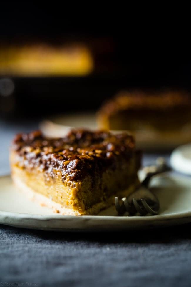 A slice of easy pumpkin pecan cheesecake on a white plate with a fork.