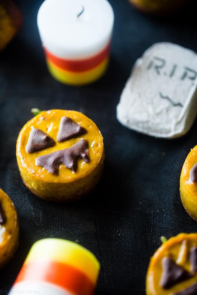 Vegan Mini Pumpkin Jack-O-Lantern Cheesecakes - These pumpkin vegan cheesecakes are easy to make, and are perfect for Halloween! They're healthy, gluten free, paleo friendly and only 200 calories! | Foodfaithfitness.com | @FoodFaithFit