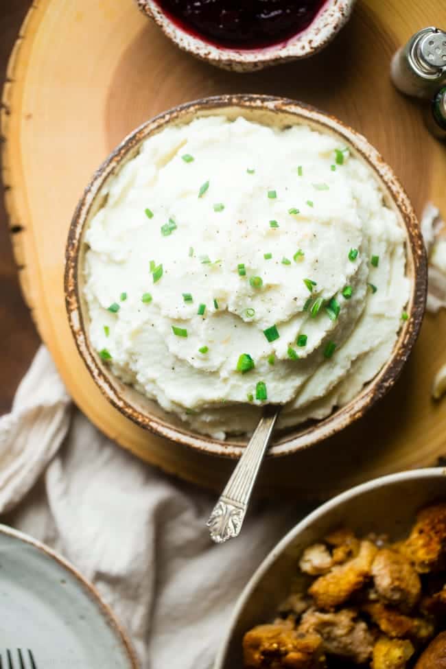 5 Ingredient Cauliflower Mashed Potatoes - These quick and easy, low carb cauliflower mashed potatoes only have 5 ingredients, 62 calories, 1 SmartPoint and use a secret ingredient to pack them with protein! Perfect for a healthy Thanksgiving! | Foodfaithfitness.com | @FoodFaithFit