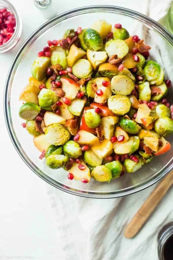Superfood Roasted Brussels Sprouts with Bacon - These salty-sweet roasted Brussels sprouts are tender, crispy and have a surprise superfood pomegranate crunch! They're the perfect, paleo-friendly healthy Thanksgiving side! | Foodfaithfitness.com | @FoodFaithFit