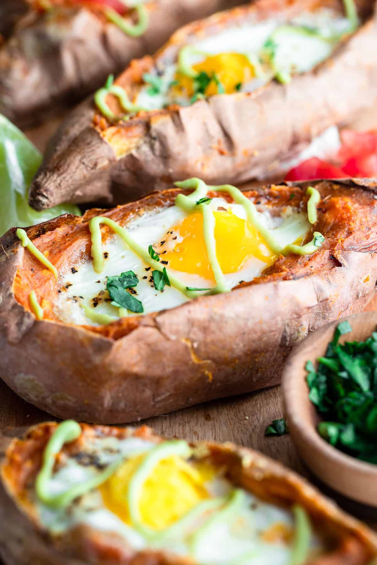 Twice Baked Mexican Sweet Potatoes - These Twice Baked Mexican Sweet Potatoes have a runny egg and a tangy lime avocado sauce! They're a healthy, gluten free and whole30 meal! | #Foodfaithfitness | #glutenfree #paleo #whole30 #healthy twice baked mexican sweet potatoes with eggs and avocado sauce drizzled on top