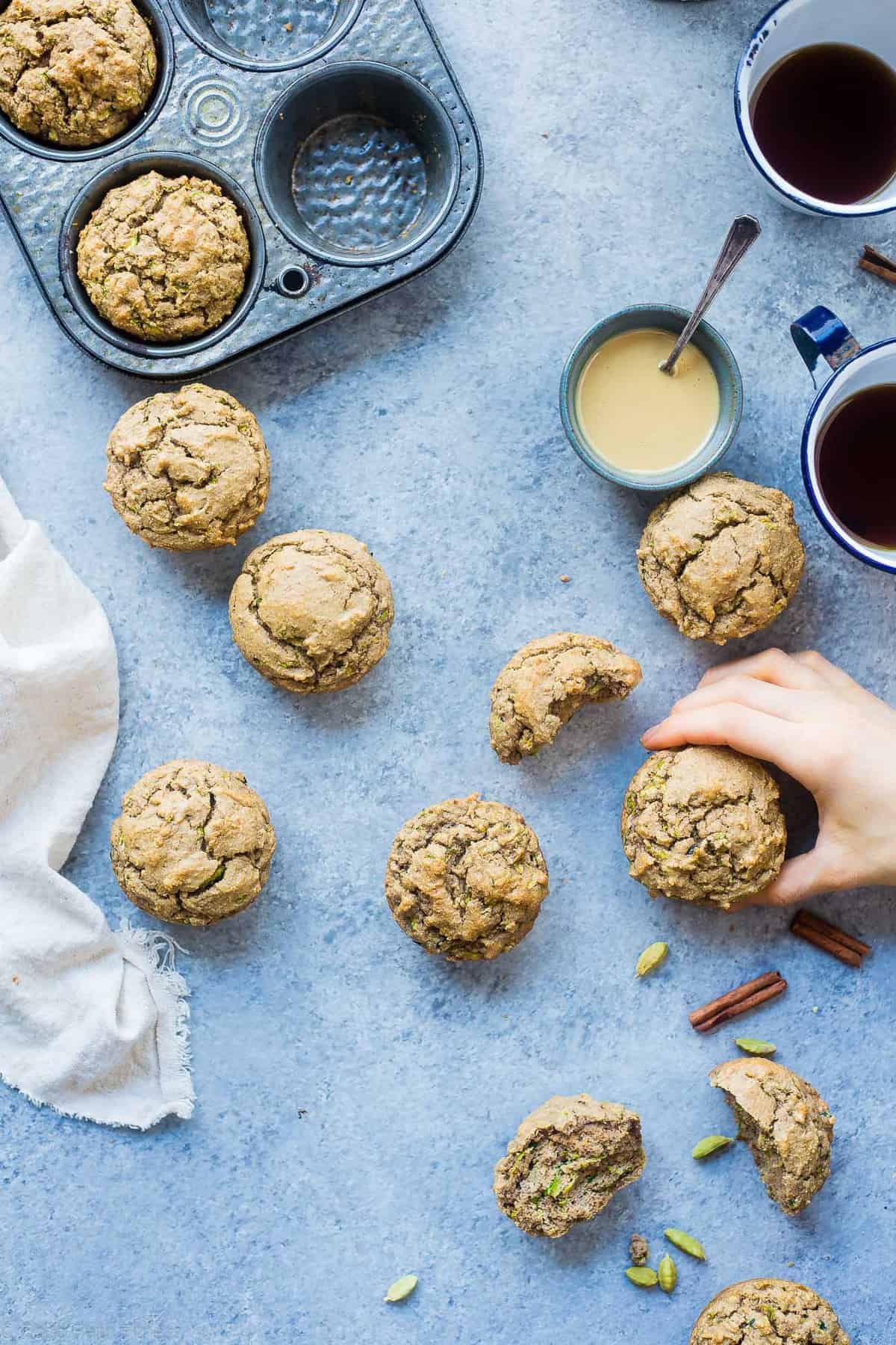 Low Carb Keto Zucchini Tahini Muffins - These low carb muffins use zucchini and tahini to make them so moist and fluffy! They're a healthy, dairy, gluten and sugar free breakfast or snack for spring! | #Foodfaithfitness | #glutenfree #lowcarb #keto #healthy #sugarfree top view of keto zucchini muffins on a table with ingredients on the side