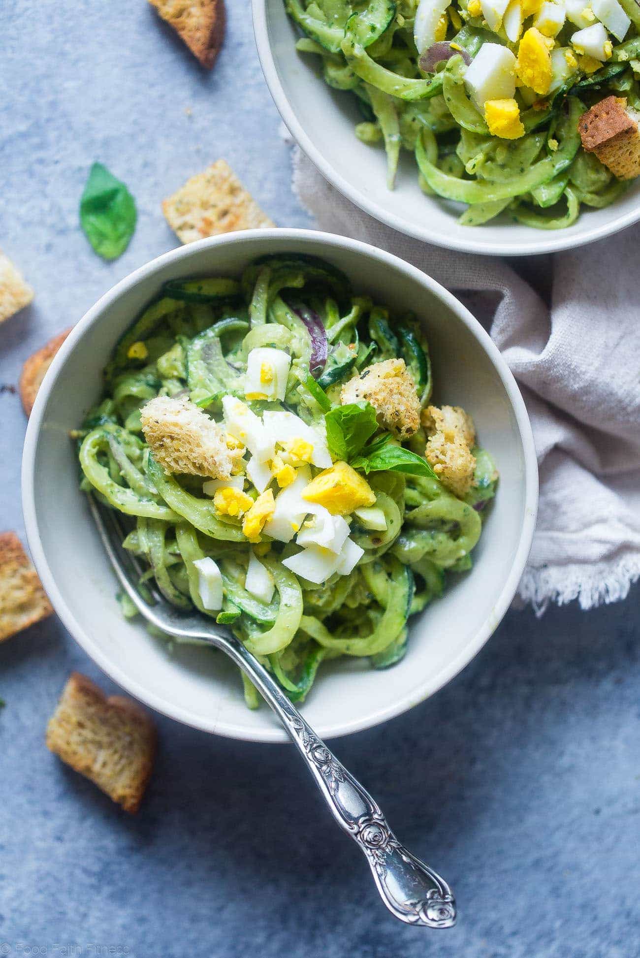 Avocado Pesto Zucchini Noodle Pasta Salad - This gluten free, healthy pasta salad uses zucchini noodles and has crunchy croutons and creamy avocado pesto! It's a low carb, easy spring side dish that's perfect for Easter! | Foodfaithfitness.com | @FoodFaithFit