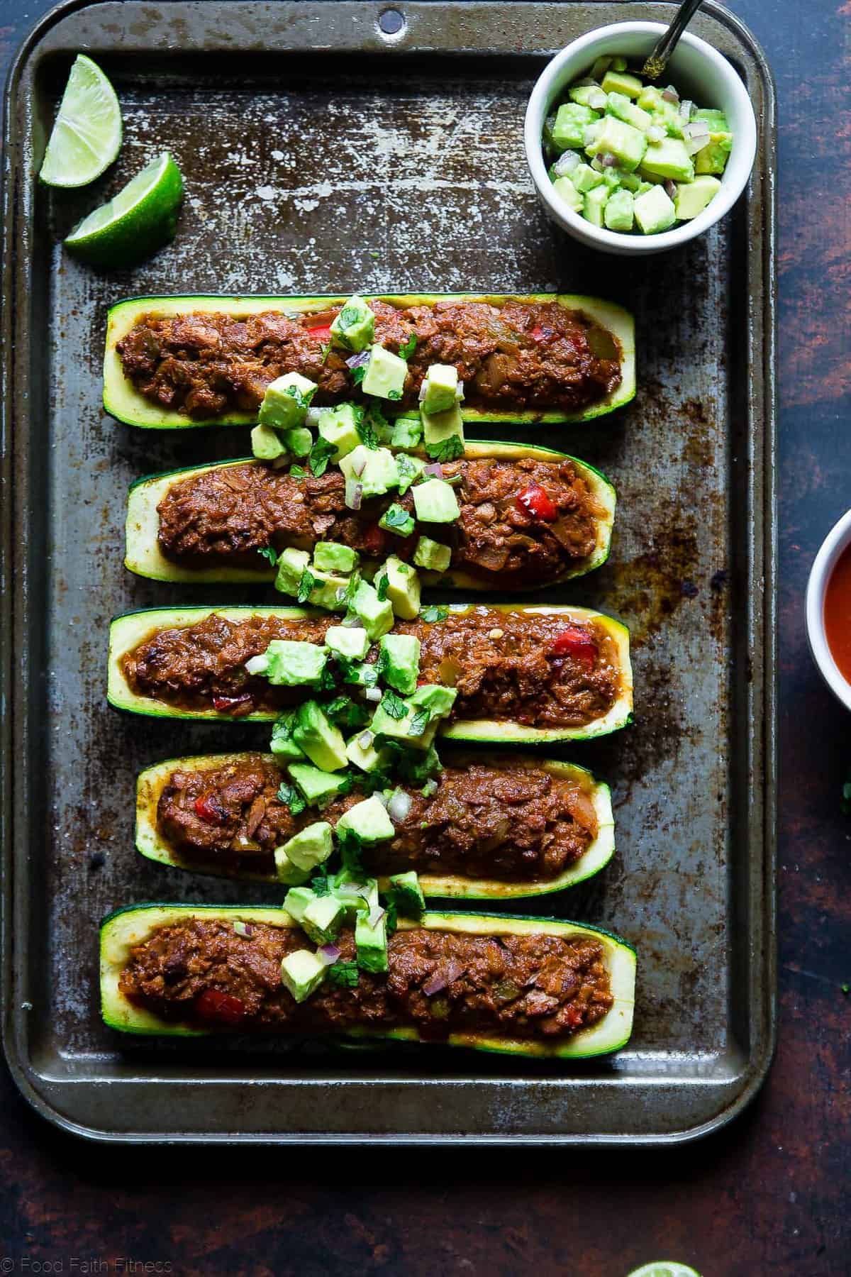 Mexican Tuna Stuffed Zucchini Boats - These quick and easy, lower carb stuffed zucchini boats are a healthy, paleo and whole30 friendly weeknight meal that are packed with protein! | Foodfaithfitness.com | @FoodFaithFit Tuna Zucchini Boats close up on a baking tray