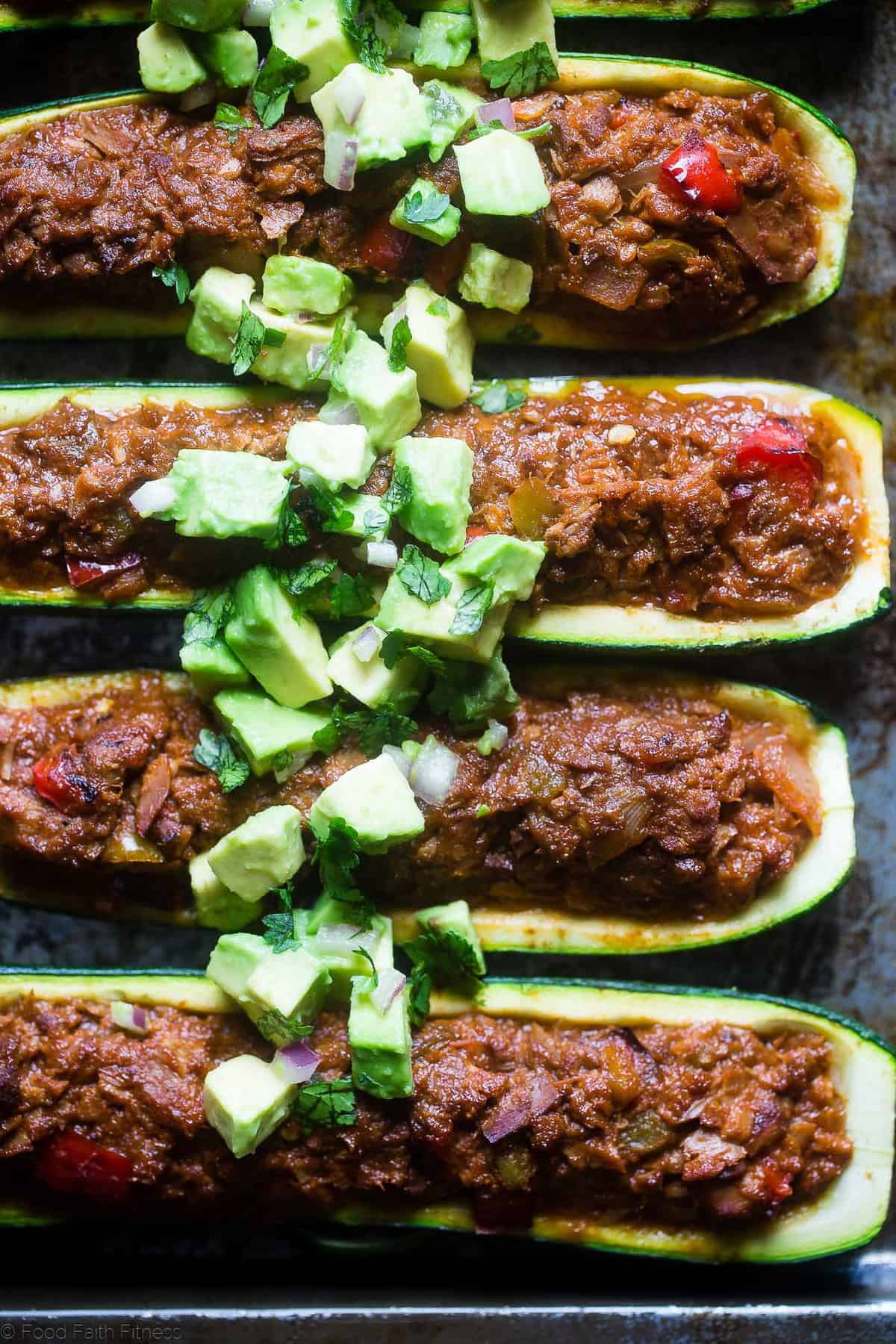 Mexican Tuna Stuffed Zucchini Boats - These quick and easy, lower carb stuffed zucchini boats are a healthy, paleo and whole30 friendly weeknight meal that are packed with protein! | Foodfaithfitness.com | @FoodFaithFit Keto Zucchini Tuna Boats close up with diced avocado on top