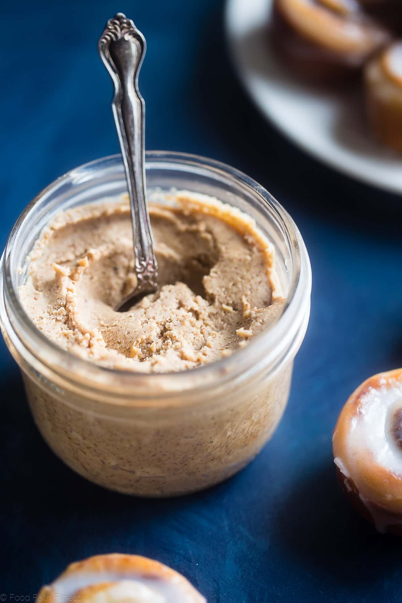 Close up of Jar of homemade cashew butter on a blue table. Recipe on Foodfaithfitness.com