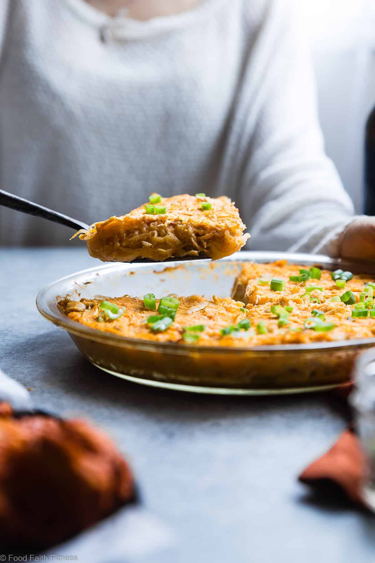 a person serving a slice of paleo buffalo chicken spaghetti squash casserole