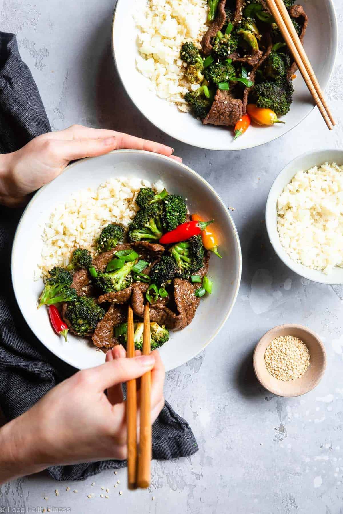 Easy Whole30 Low Carb Beef and Broccoli - This keto beef and broccoli is an EASY, one-pot weeknight meal that even picky eaters will love! So much yummier and healthier than takeout too! | #Foodfaithfitness | #Glutenfree #Keto #Paleo #Lowcarb #Whole30 a bowl of Keto Beef and Broccoli being eaten with chopsticks