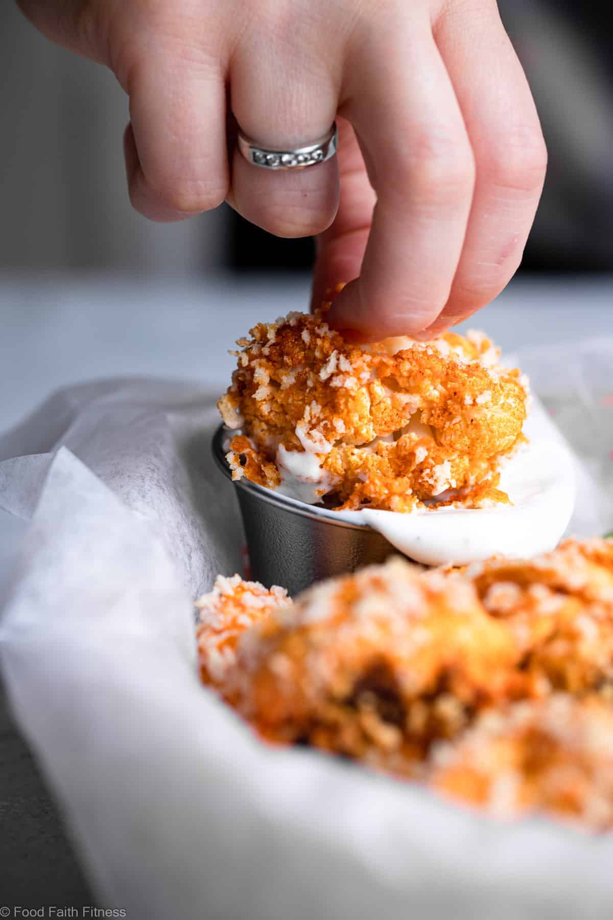 Air Fryer Buffalo Cauliflower - Air fried buffalo cauliflower wings are an easy recipe that even picky kids will love! Gluten free and vegan option and so crispy and crunchy too! | #Foodfaithfitness | #Glutenfree #Cauliflower #Healthy #AirFryer #Vegan dipping fried cauliflower wings into sauce