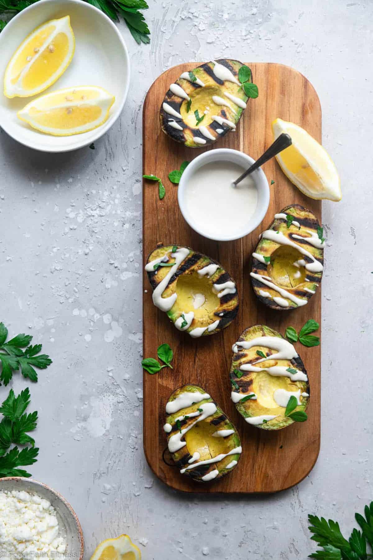 Grilled Avocado with Feta Tahini Sauce - These smoky and creamy grilled avocados are drizzled with a sweet and tangy feta and tahini sauce for an easy summer dinner that's healthy , keto, low carb and delicious! | #Foodfaithfitness | #Glutenfree #healthy #lowcarb #keto #grilling
