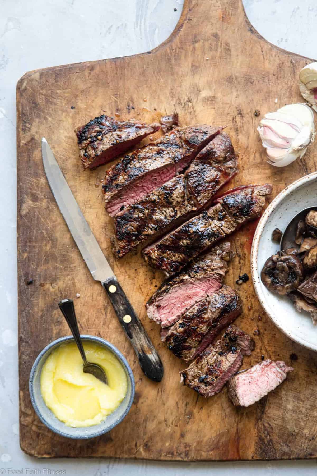 Keto Steak with Garlic Butter Mushrooms - This keto steak recipe is topped with garlic butter mushrooms and grilled to perfection! A low carb, paleo and whole30 healthy Summer dinner! | #Foodfaithfitness | #Glutenfree #Paleo #Keto #Lowcarb #whole30 sliced steak on a cutting board