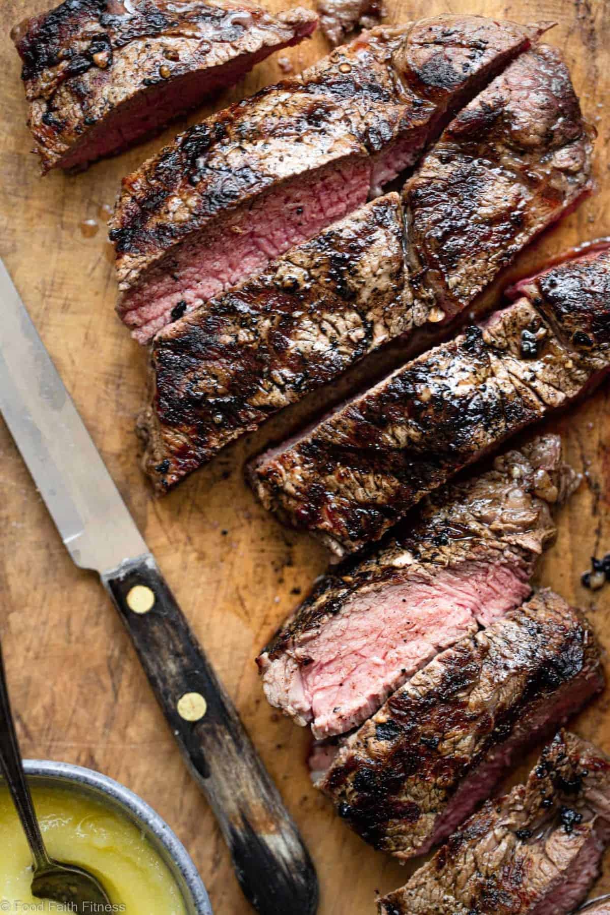 Keto Steak with Garlic Butter Mushrooms - This keto steak recipe is topped with garlic butter mushrooms and grilled to perfection! A low carb, paleo and whole30 healthy Summer dinner! | #Foodfaithfitness | #Glutenfree #Paleo #Keto #Lowcarb #whole30 close up of sliced keto steak on a cutting board