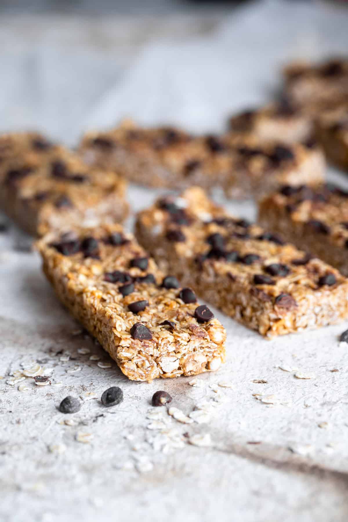 Healthy Chewy Chocolate Chip Granola Bars - This Healthy Chewy Granola Bar Recipe is made with wholesome, simple, pantry essential ingredients! Loaded with chocolate chips and great for kids or adults! | #Foodfaithfitness | #kidfriendly #healthy #snack #eggfree #backtoschool healthy chewy granola bars in a line on a table