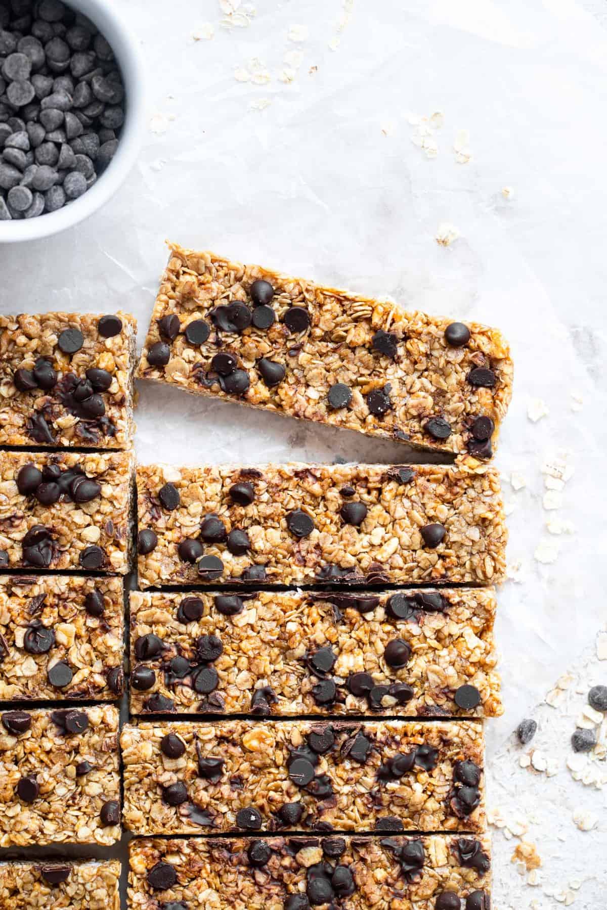 Healthy Chewy Chocolate Chip Granola Bars - This Healthy Chewy Granola Bar Recipe is made with wholesome, simple, pantry essential ingredients! Loaded with chocolate chips and great for kids or adults! | #Foodfaithfitness | #kidfriendly #healthy #snack #eggfree #backtoschool healthy chewy granola bar recipe in a row with one bar removed