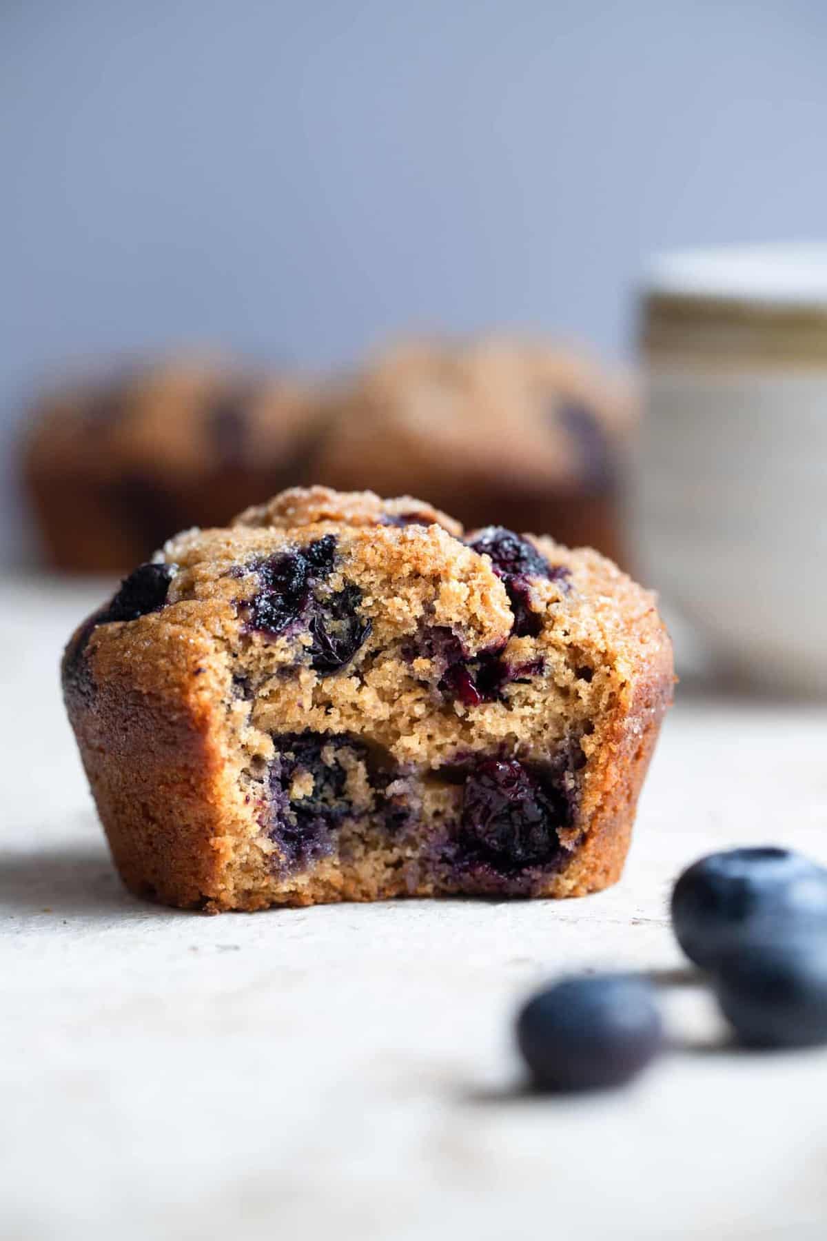 close up of whole wheat blueberry muffins with a bite taken out of one