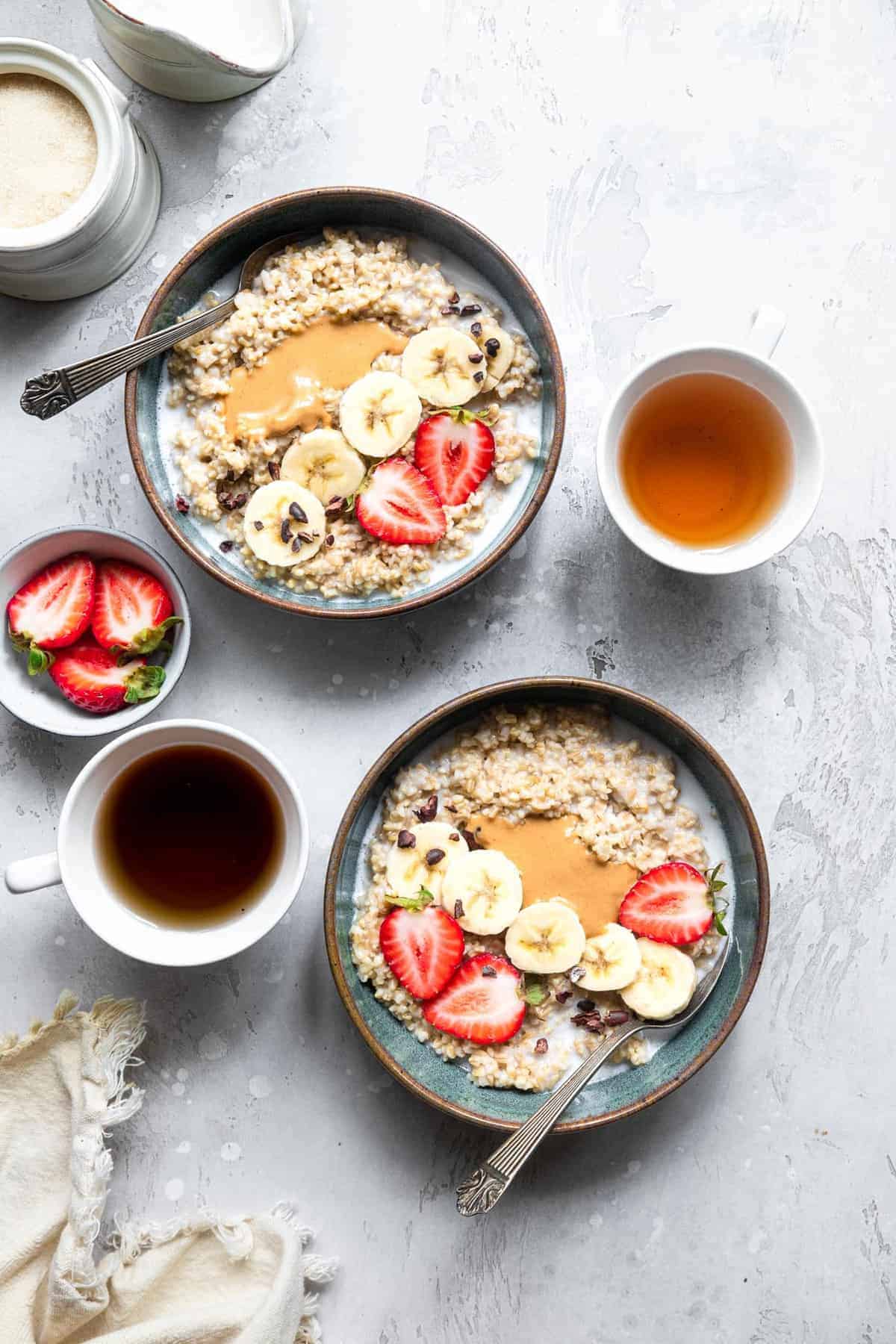 Instant Pot Steel Cut Oats - a quick, simple breakfast that are only 2 ingredients! Naturally gluten free, vegan, healthy and SO filling! Great for meal prep too! | #Foodfaithfitness | #Glutenfree #vegan #healthy #sugarfree #dairyfree #Instantpot Instant Pot steel cut oatmeal in 2 bowls with strawberries