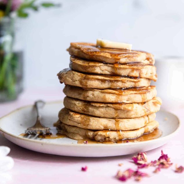 a stack of Healthy Vegan Pancakes with butter and syrup