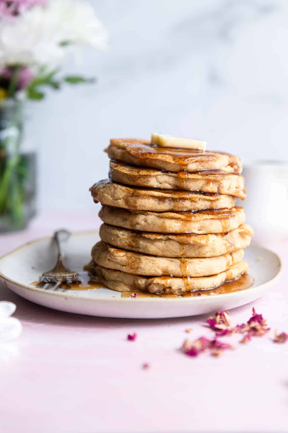 Fluffy Whole Wheat Vegan Pancakes -These healthy Vegan Pancakes are so fluffy and light you will never know they are healthy, whole grain and dairy and egg free! Your new go to recipe! | #Foodfaithfitness | #healthy #vegan #eggfree #dairyfree #wholewheat a stack of Healthy Vegan Pancakes with butter and syrup