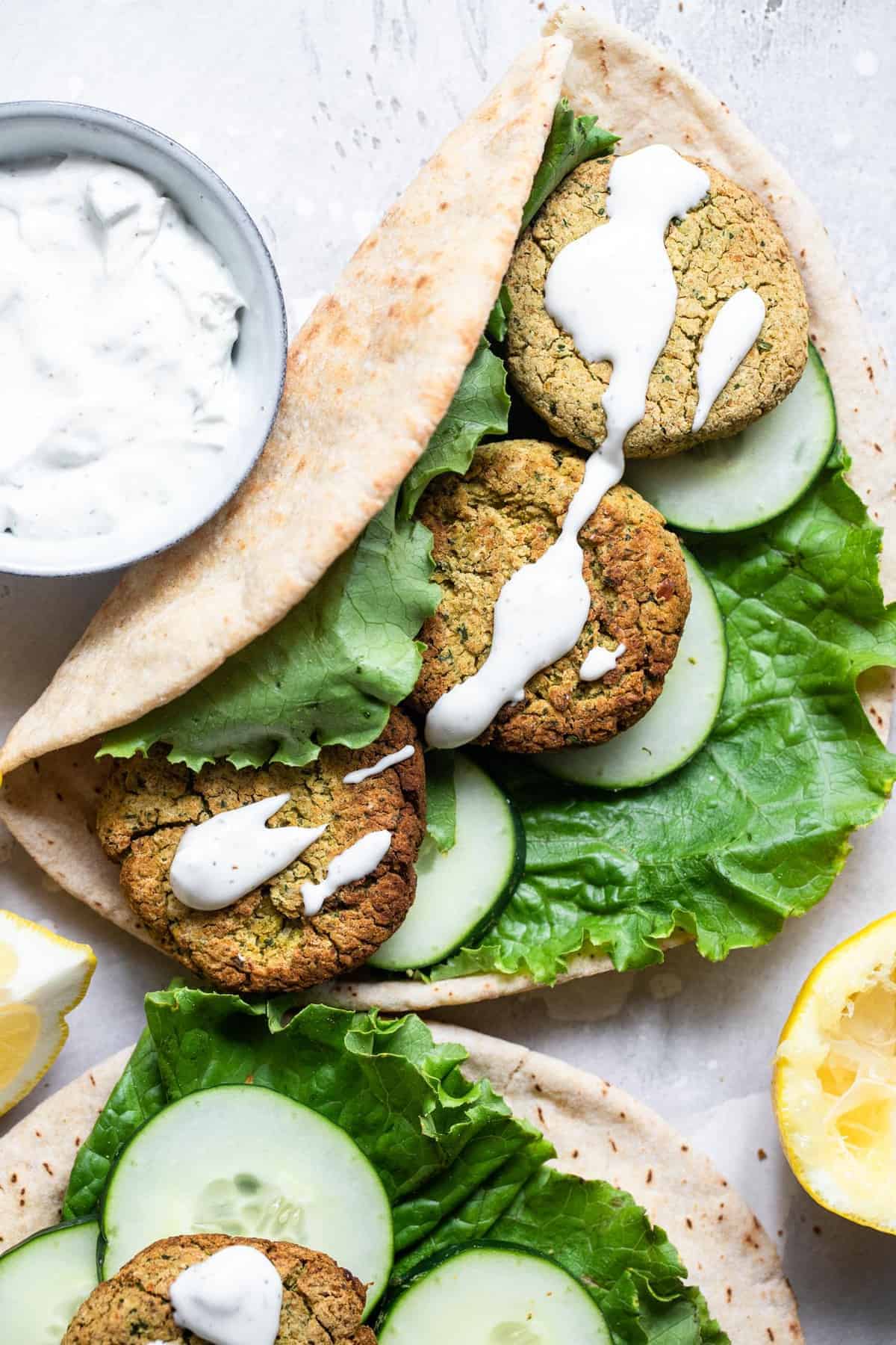 Crispy Air Fryer Falafel - This healthy Air Fryer Falafel is SO crispy you will never believe that it is not deep fried! Easy, gluten free, vegan friendly and so delicious! | #Foodfaithfitness | #Vegan #Dairyfree #Glutenfree #Airfryer #Healthy baked falafel in a pita bread with yogurt sauce