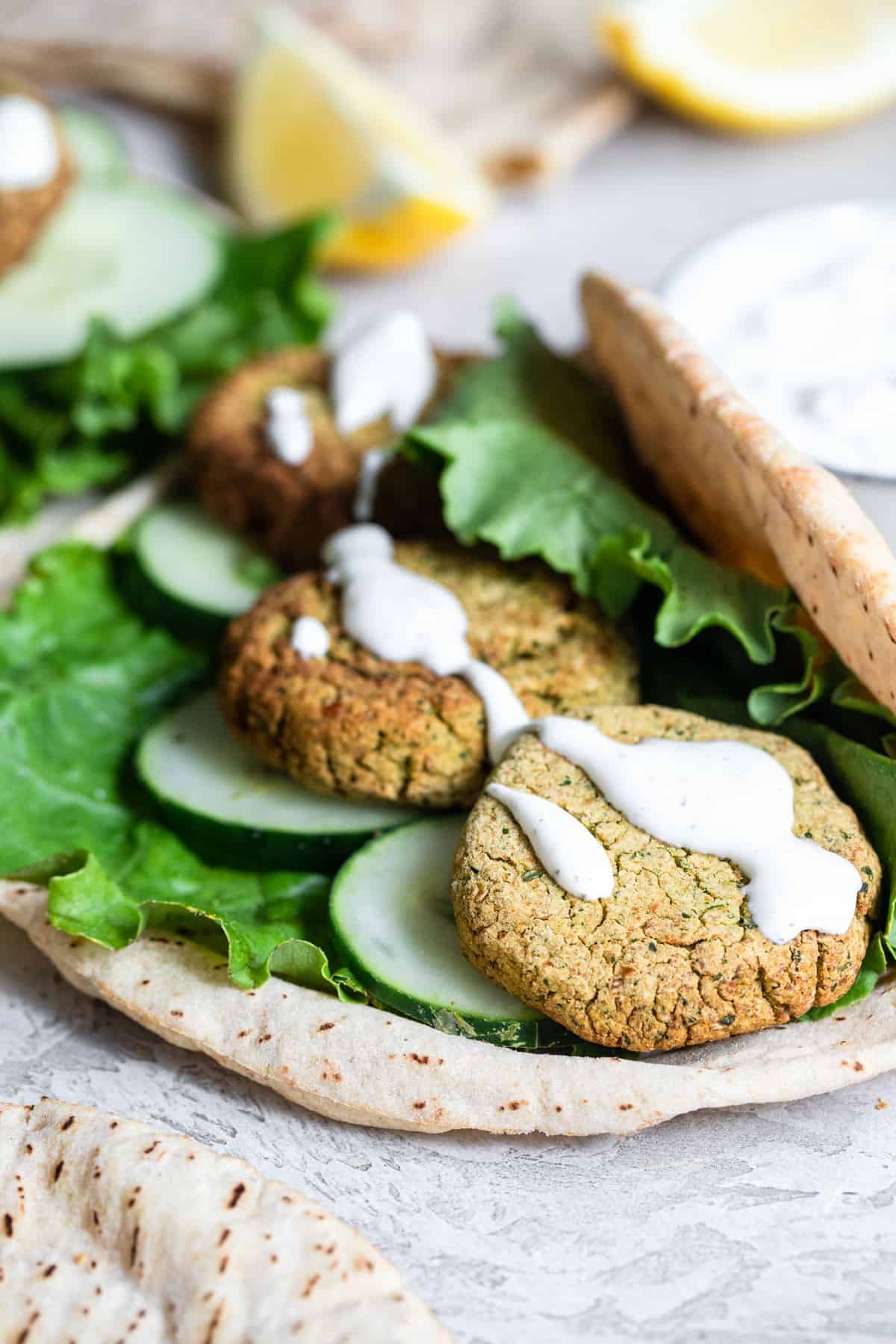 Crispy Air Fryer Falafel - This healthy Air Fryer Falafel is SO crispy you will never believe that it is not deep fried! Easy, gluten free, vegan friendly and so delicious! | #Foodfaithfitness | #Vegan #Dairyfree #Glutenfree #Airfryer #Healthy Air Fryer Falafel in a warp with sauce