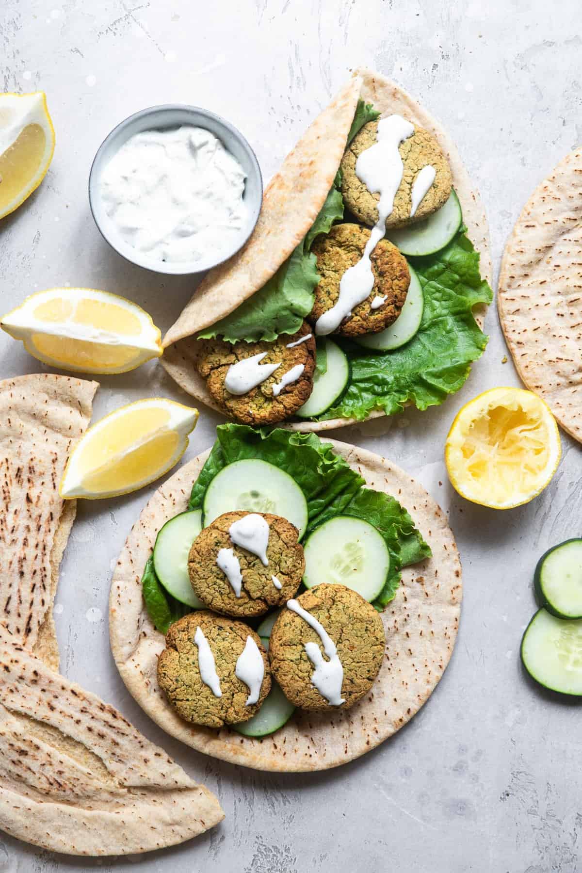 Crispy Air Fryer Falafel - This healthy Air Fryer Falafel is SO crispy you will never believe that it is not deep fried! Easy, gluten free, vegan friendly and so delicious! | #Foodfaithfitness | #Vegan #Dairyfree #Glutenfree #Airfryer #Healthy Air fryer falafel on pita bread on a table