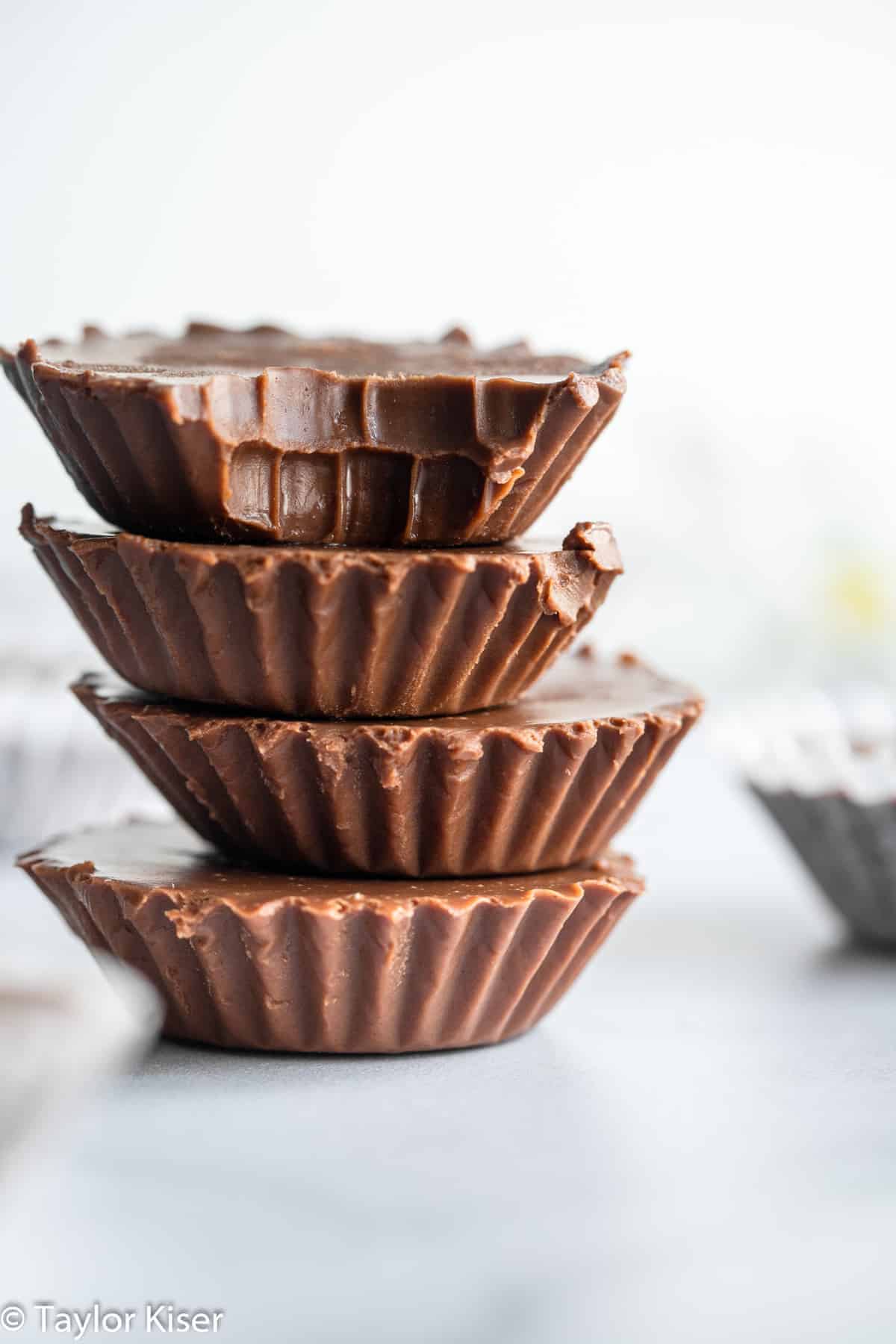 No Bake Keto Chocolate Peanut Butter Fat Bombs - These No Bake Fat Bombs are an easy, 4 ingredient dessert that are sugar free, gluten free and low carb! Delicious and simple even if you're not keto! | #Foodfaithfitness | #glutenfree #lowcarb #sugarfree #keto #healthy stack of keto chocolate peanut butter fat bombs