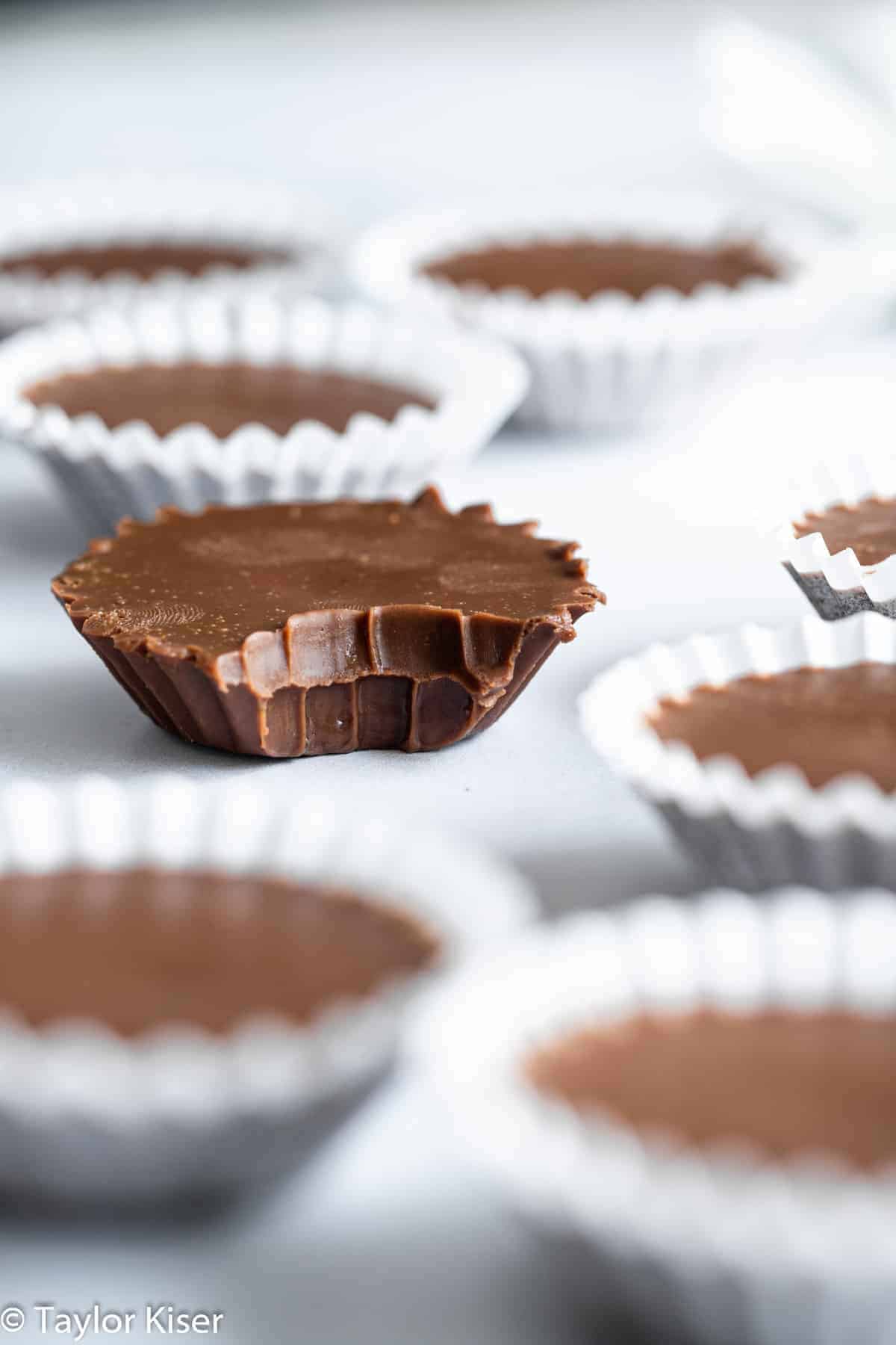 No Bake Keto Chocolate Peanut Butter Fat Bombs - These No Bake Fat Bombs are an easy, 4 ingredient dessert that are sugar free, gluten free and low carb! Delicious and simple even if you're not keto! | #Foodfaithfitness | #glutenfree #lowcarb #sugarfree #keto #healthy chocolate fat bombs with a bite taken out of one