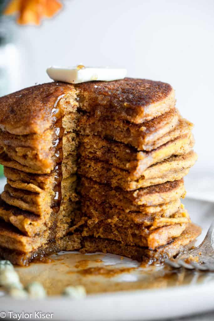 a stack of whole wheat healthy pumpkin pancakes with a cut down the middle