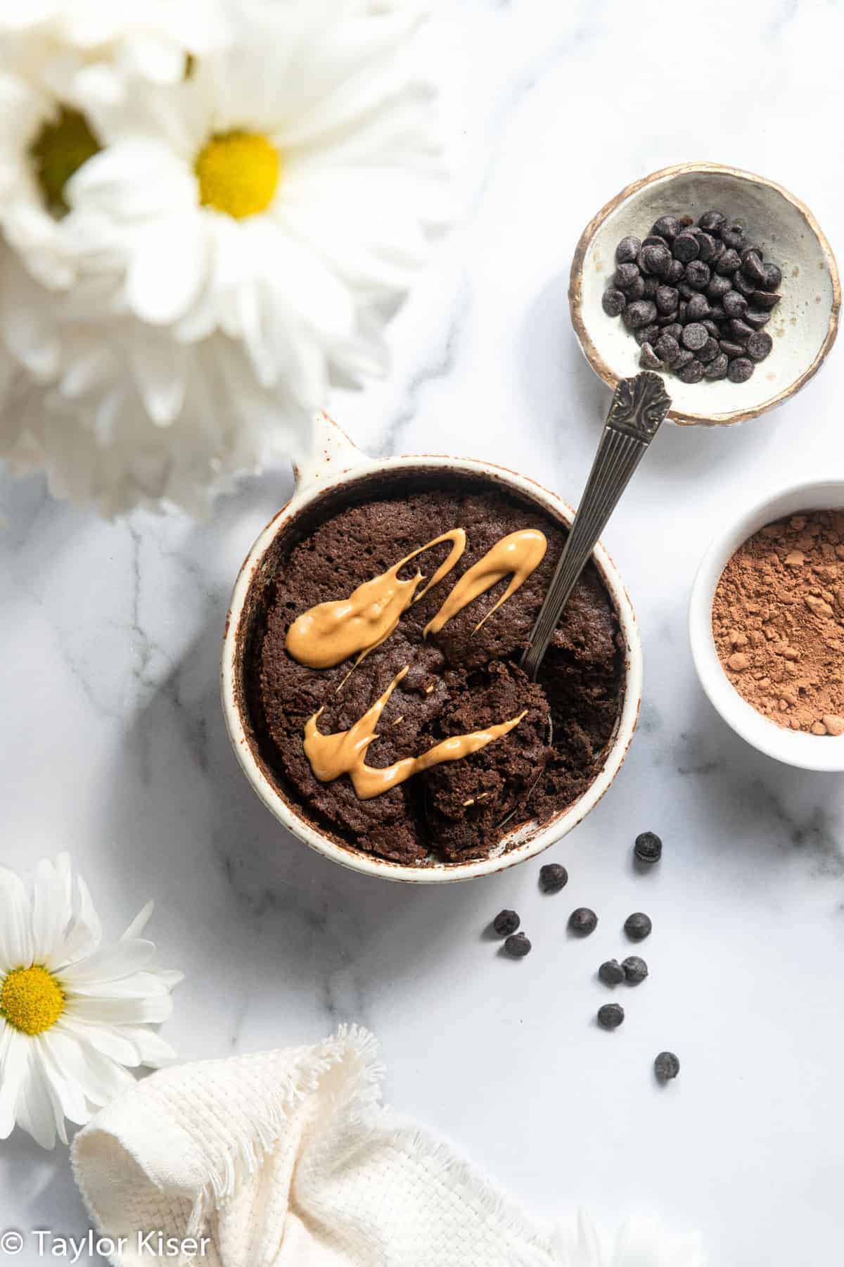 Almond flour mug cake on a table with flowers