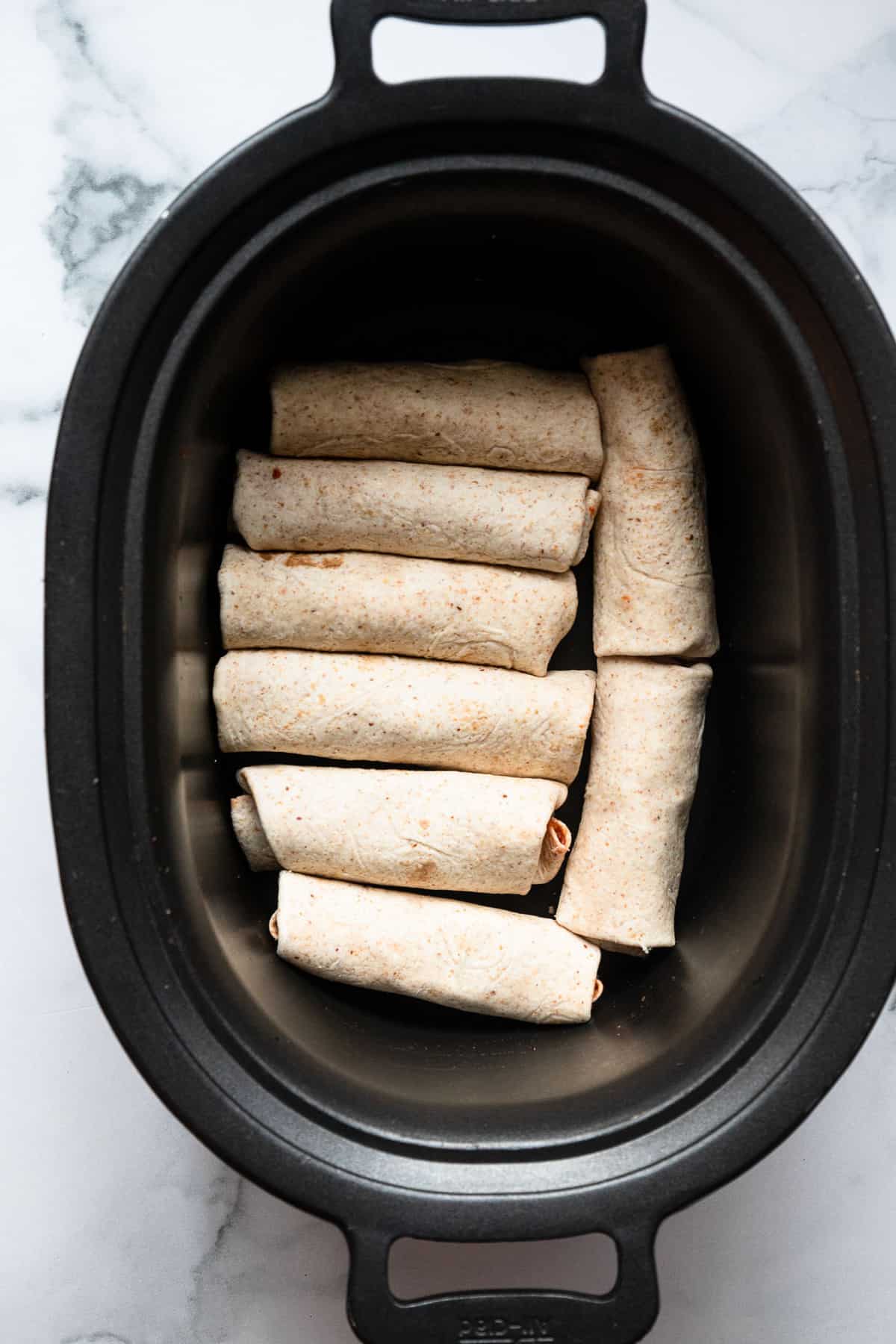 Healthy Crock Pot Chicken Enchiladas - an easy, healthy weeknight dinner that the whole family will love - even picky eaters! Makes great leftovers and freezer meals too! | #Foodfaithfitness | #healthy #dinner #slowcooker #crockpot #kidfriendly slow cooker enchiladas before the sauce is poured on