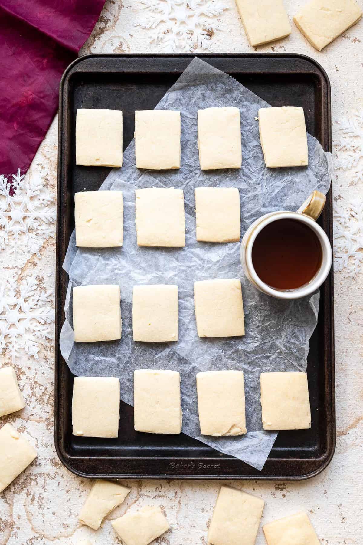 Dairy Free Vegan Shortbread Cookies - Crunchy, buttery but naturally dairy free and only 3 ingredients! Perfect for Christmas! | #Foodfaithfitness | #dairyfree #eggfree #nutfree #vegan #shortbread vegan shortbread cookies on a cookie sheet with a cup of coffee