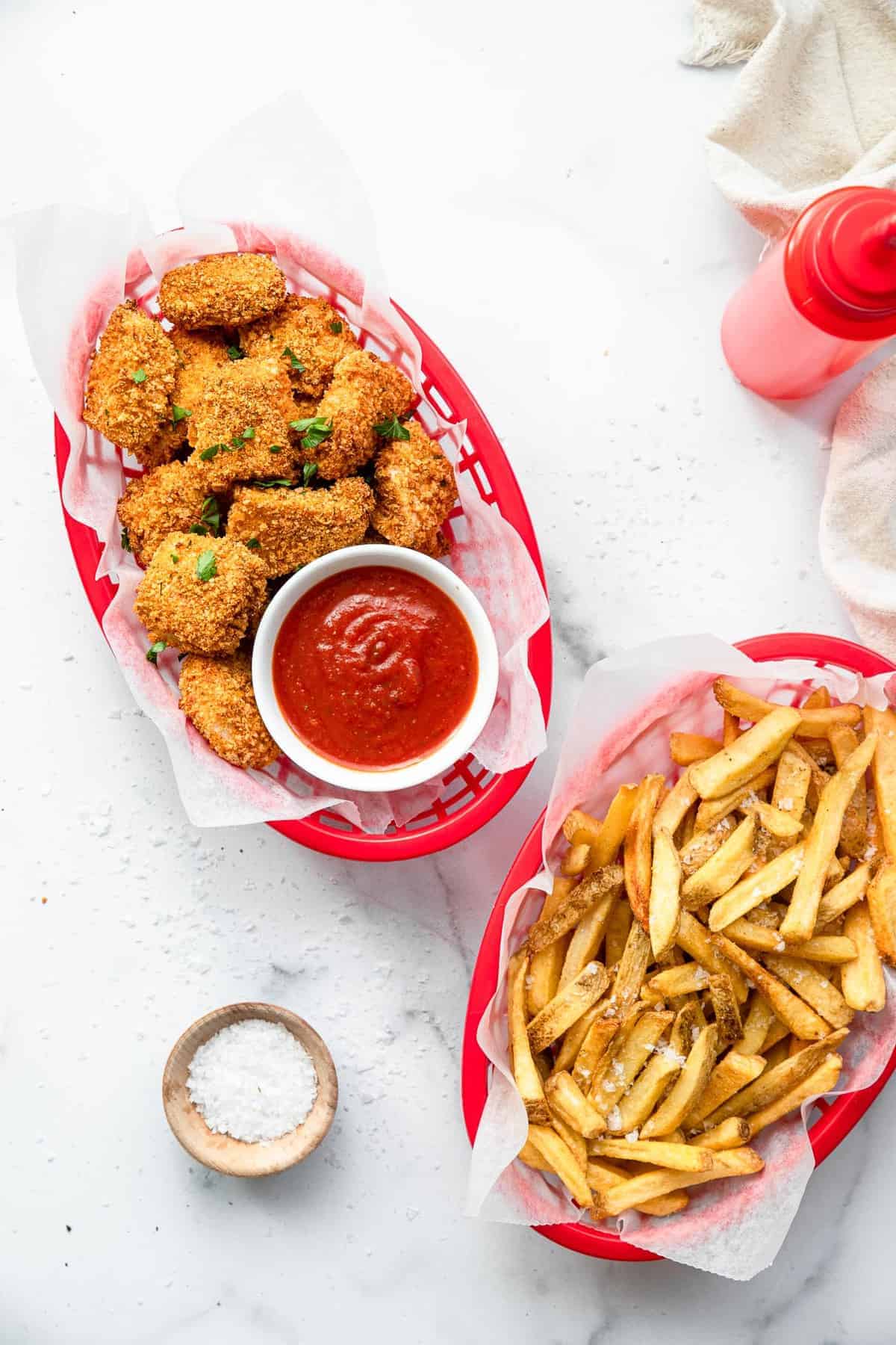 two baskets of air fried chicken nuggets on a table