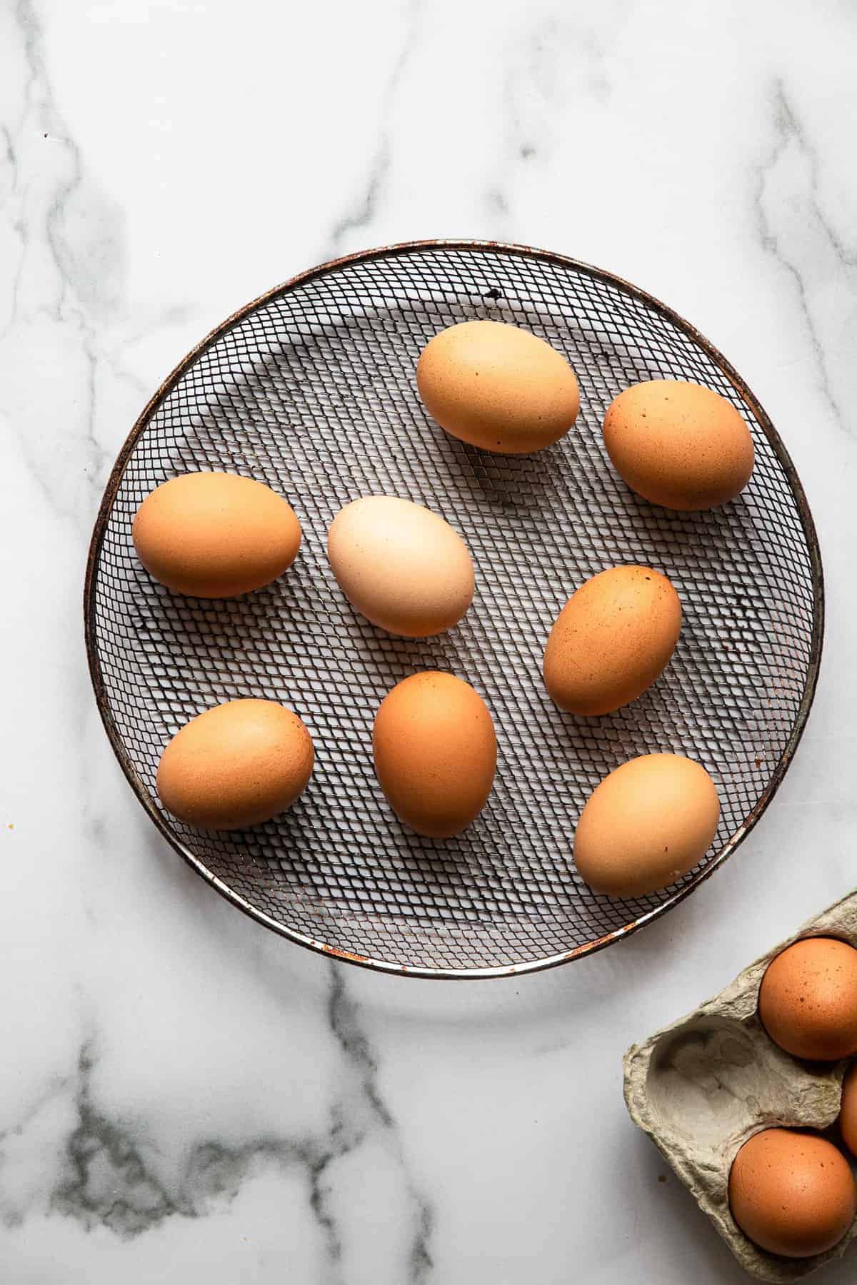 Air Fryer Hard Boiled Eggs - These 1 ingredient air fryer hard boiled eggs are even easier than boiling them and come out perfect every time! Gluten free, keto, paleo, low carb and healthy! The perfect snack or addition to a meal! | #Foodfaithfitness | #airfryer #glutenfree #keto #paleo #lowcarb air fryer eggs in the mesh basket of an air fryer