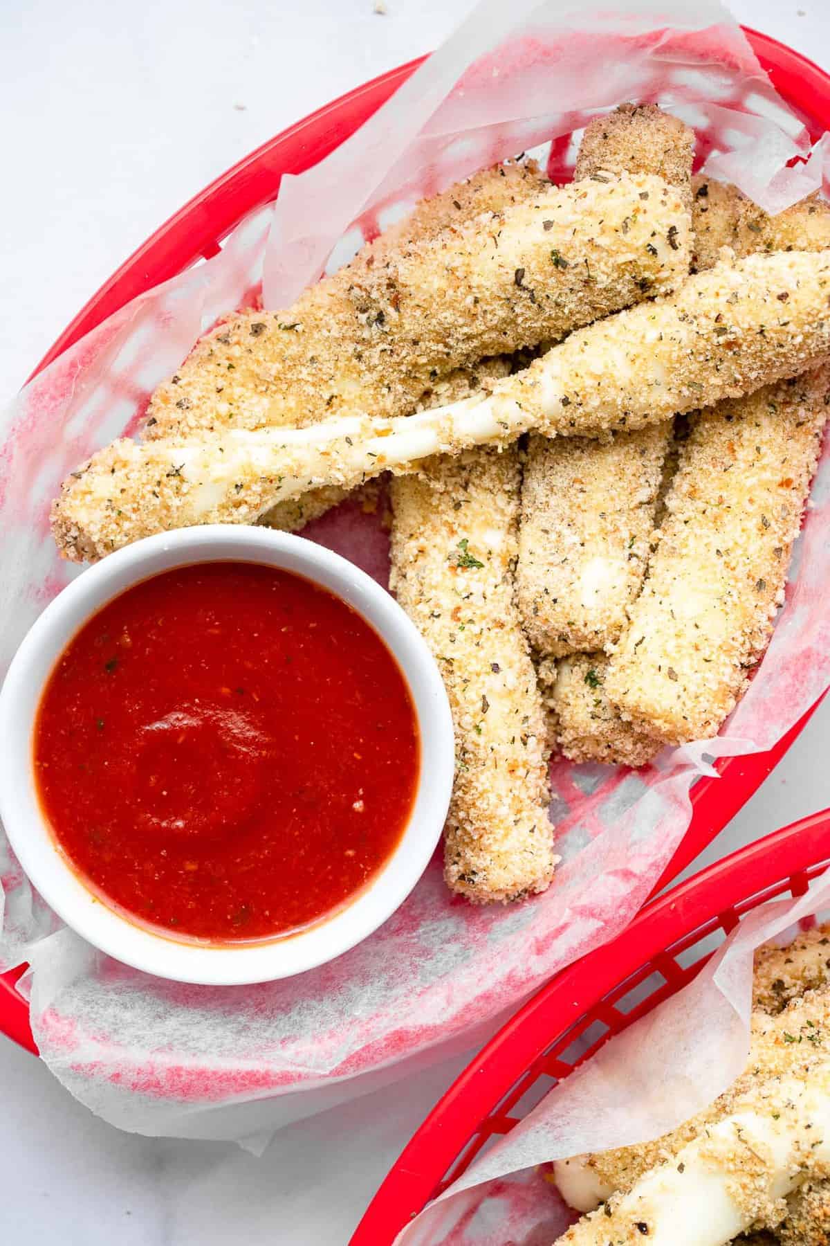 Crispy Oven Baked Mozzarella Sticks - This Oven Baked Mozzarella Sticks Recipe is SO crispy and gooey, you will never believe they are baked, not fried, and only 5 ingredients! | #Foodfaithfitness | #glutenfree #healthy #appetizer #gameday oven baked mozzarella sticks pulled apart with dip